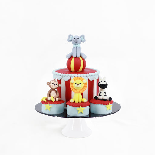 Circus themed cake decorated with fondant animals of elephant, monkey, lion and zebra
