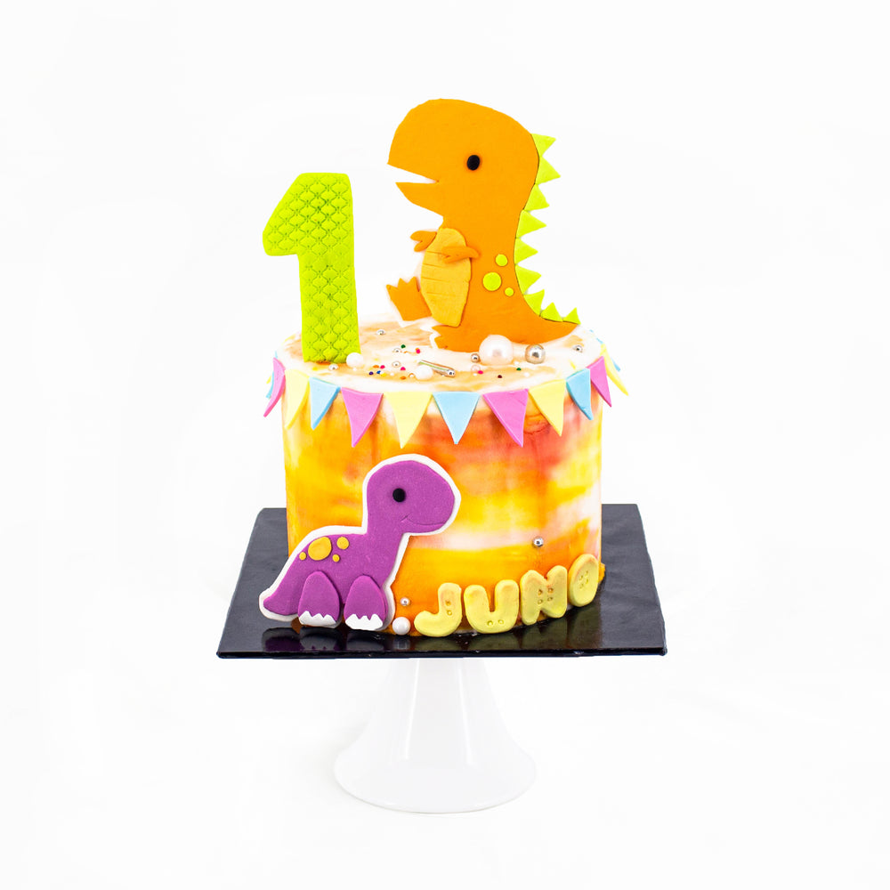 Baby dinosaur cake frosted with orange buttercream
