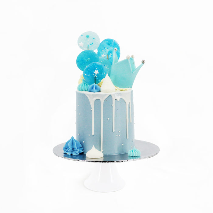 Blue buttercream cake with white drip, with a fondant blue crown