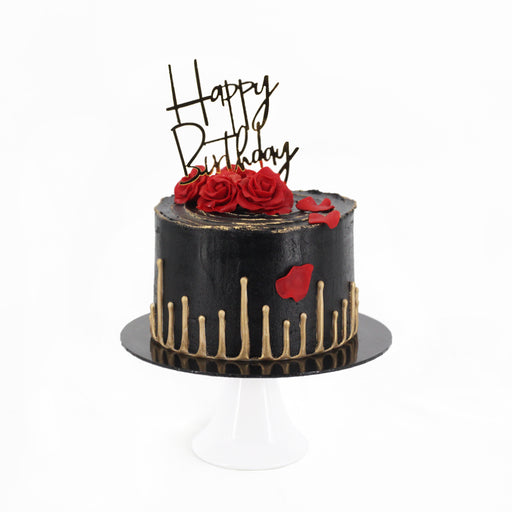 Dark chocolate ganache cake with gold accents, topped with a fondant rose