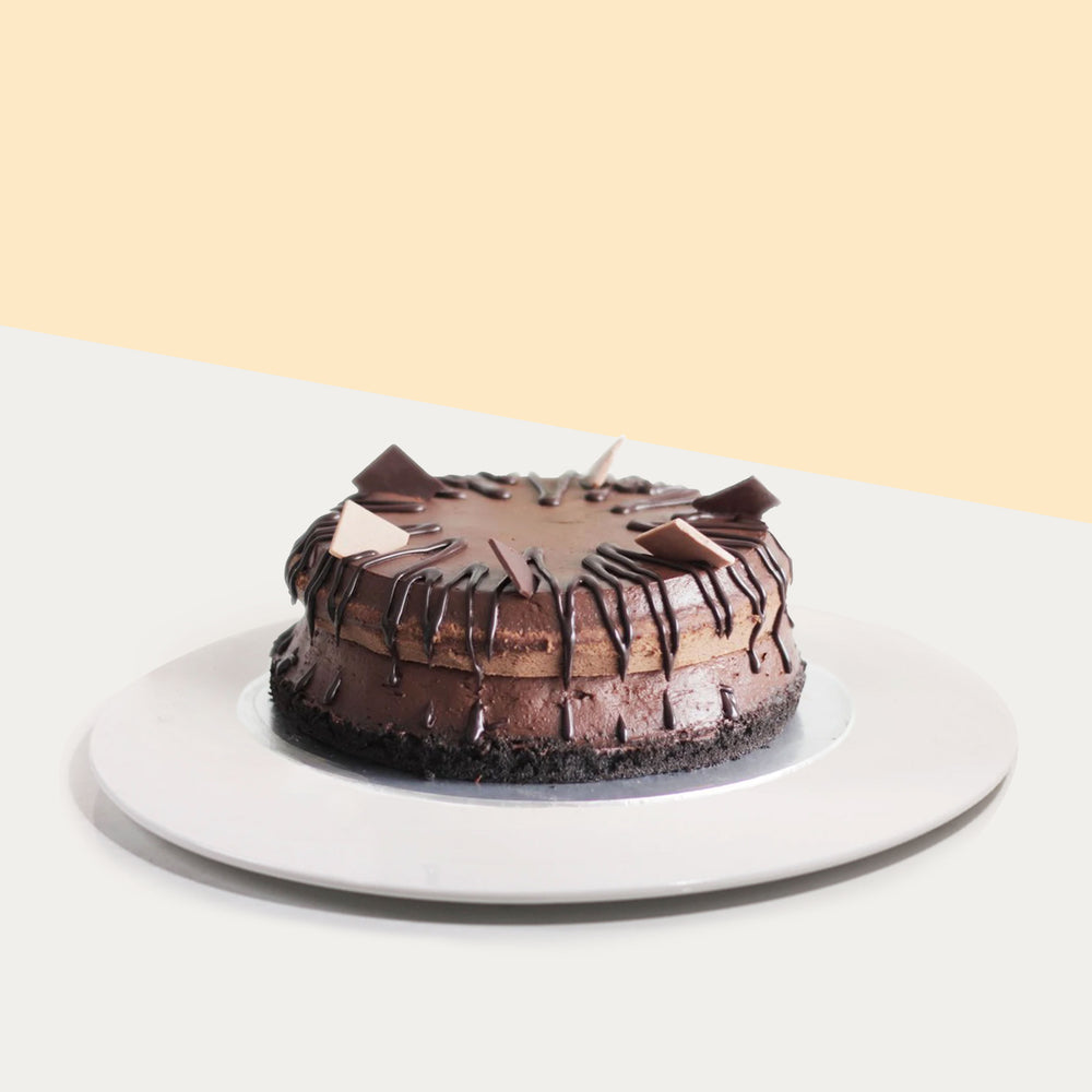 Dark chocolate cake topped with chocolate glaze and chocolate pieces