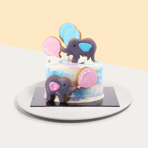 Gender reveal cake with elephant cookies, and pink and blue elements
