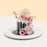 Black buttercream cake, glazed with white chocolate ganache, decorated with fresh flowers