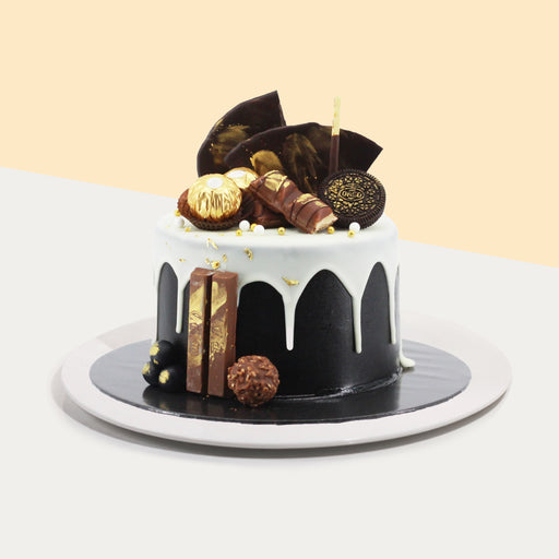 Black cake designed for men, topped with kit kats, ferrero rocher, kinder bueno, oreos and chocolate shards