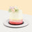 Cake with colorful frills from a pink to white gradient, topped with fresh flowers