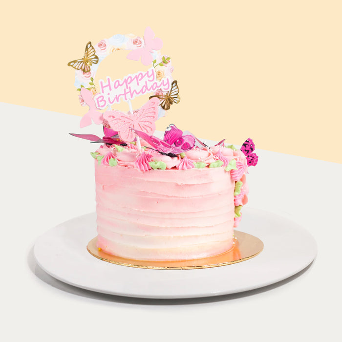 Butter cake with pink buttercream icing, decorated with paper butterflies