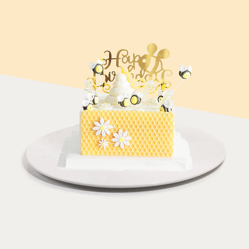 Cuboid cake made with chamomile infused sponge, with cream and honey layers, with a honey comb design made of white chocolate