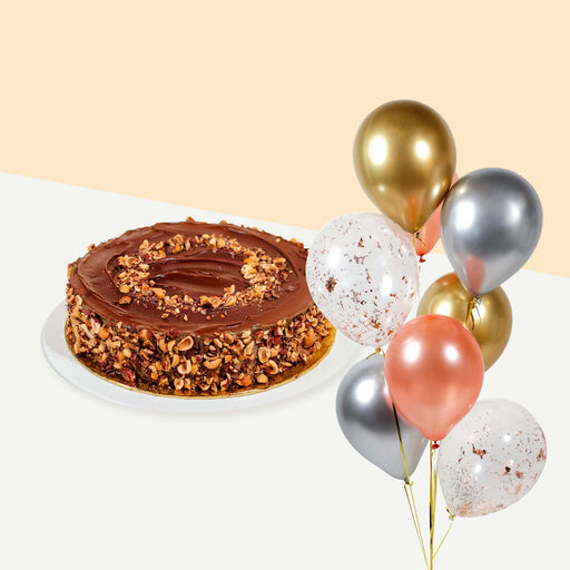 Cake coated with hazelnut spread, garnished with hazelnuts on the top and sides bundled with a set of balloons