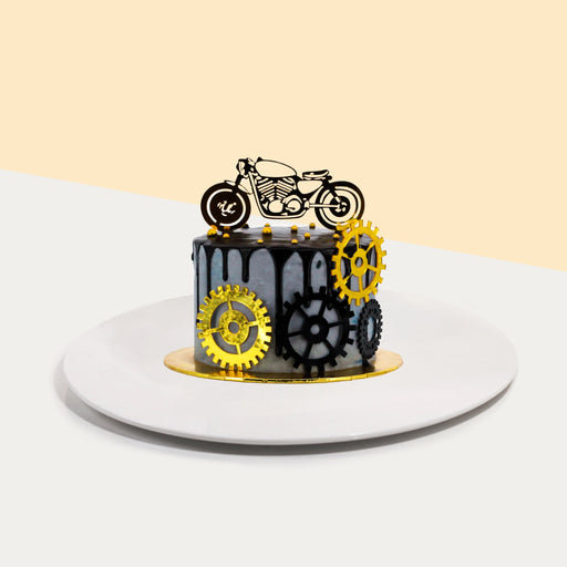 Butter cake designed with motorbike elements, with 2d printed cogs and bike cake topper