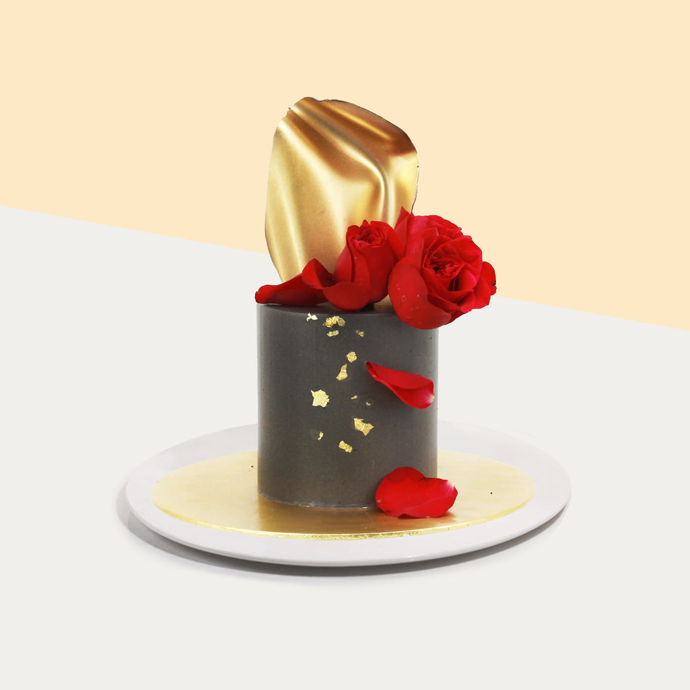 Elegant butter cake, decorated with red roses, fondant gold sheet, and edible gold flakes