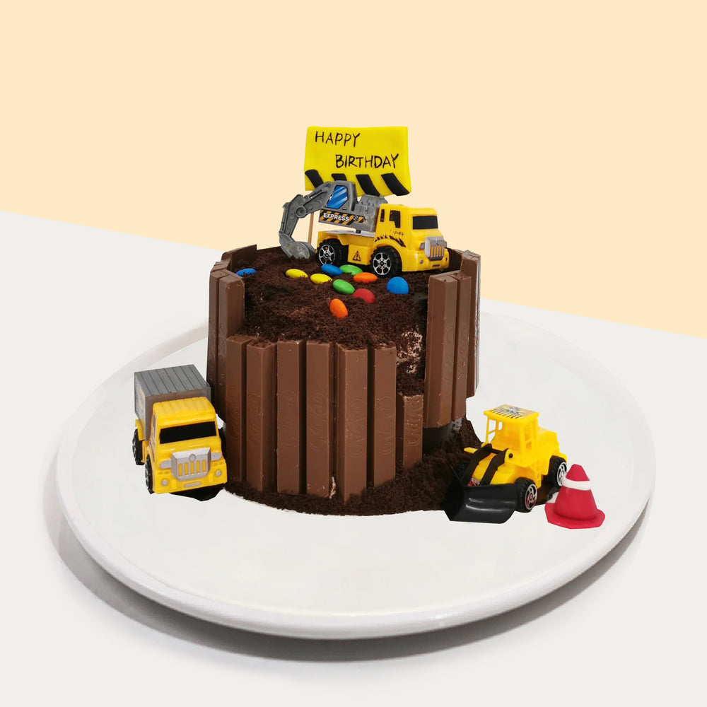 Construction themed cake, with chocolate wafers and toy construction lorries