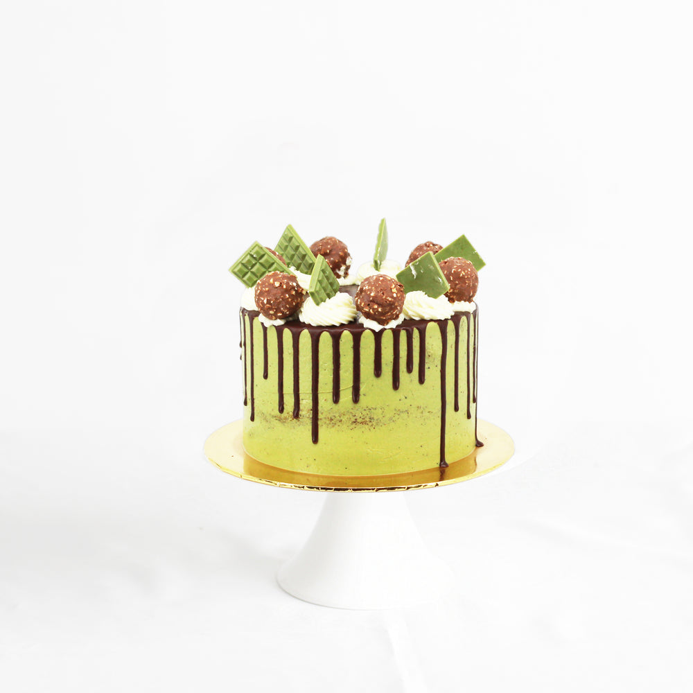 Cake with matcha buttercream, topped with dark chocolate drizzle, and Ferrero Rocher toppings