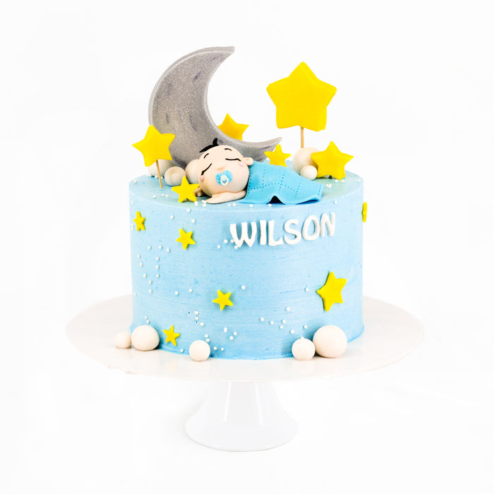 Baby blue cake with a sleeping baby figurine made from fondant