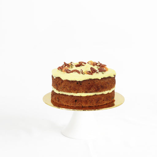 Carrot cake with pecan nuts, topped with cheese and pecan nuts, pumpkin seeds and apricot bits