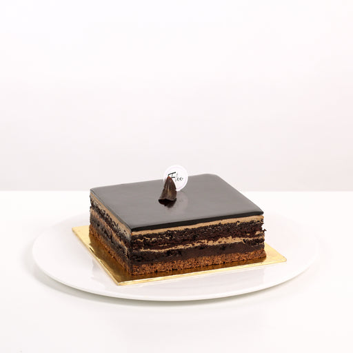 Square cuboid cake with a crunchy cookie base, moist chocolate cake, coffee buttercream and dark chocolate ganache