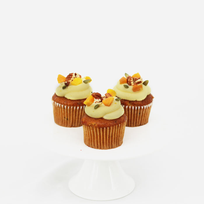 Carrot pecan cupcakes with cream cheese, pecan nuts, pumpkin seeds and dried apricots