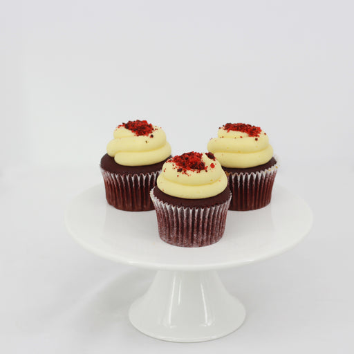 Red velvet cupcakes with cream cheese, garnished with red velvet crumbs