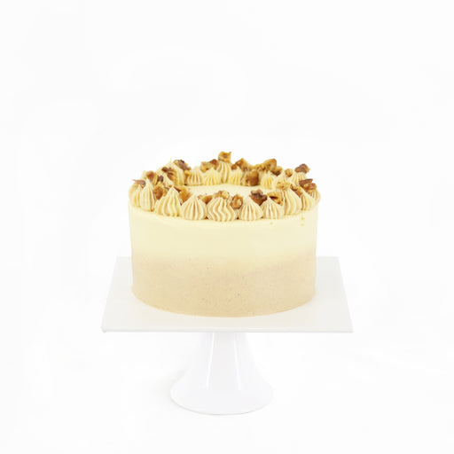 Moist carrot cake frosted with cream cheese, topped with walnuts