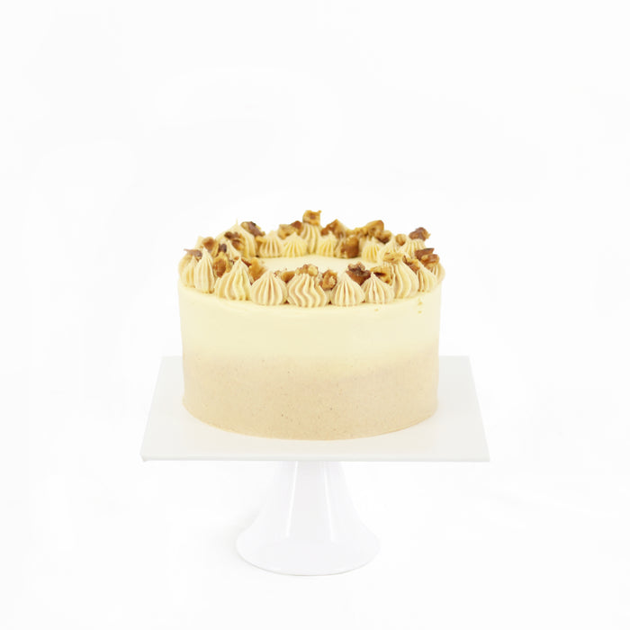 Moist carrot cake frosted with cream cheese, topped with walnuts