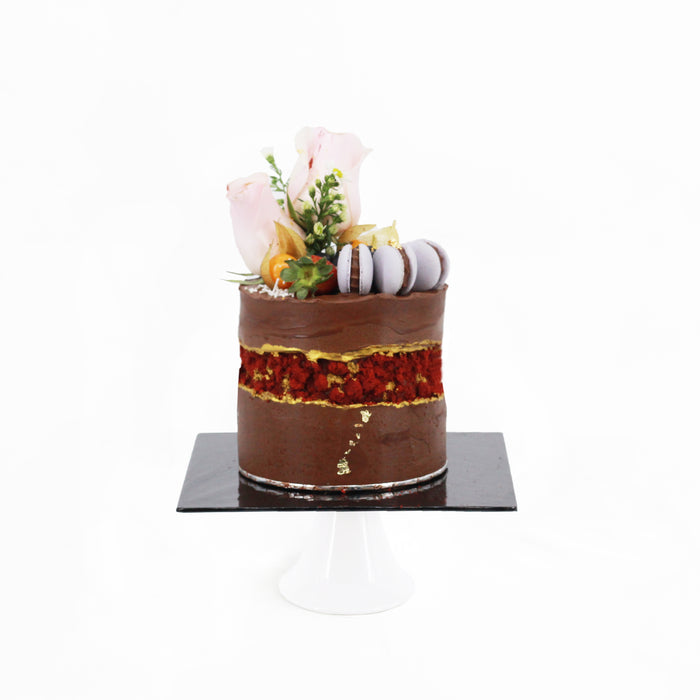 Chocolate butter cake with berries compote layers, with a fault line design with gold and red accents