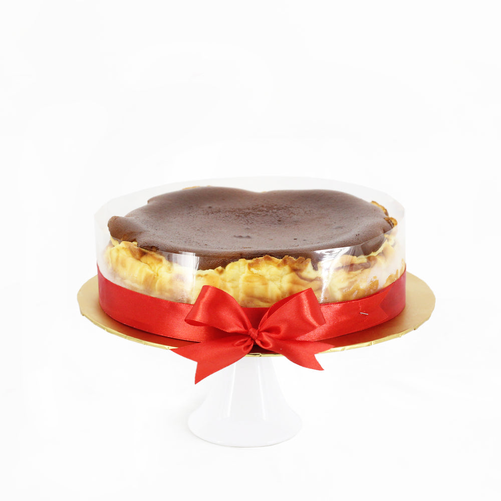 Japanese burnt cheesecake, with transparent rim and red ribbon