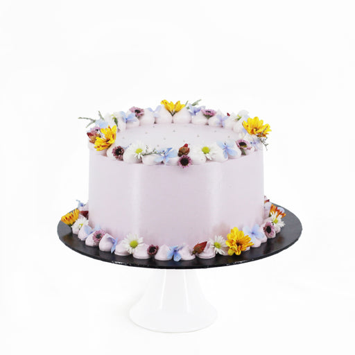 Pastel coloured cake, decorated with dainty edible flowers