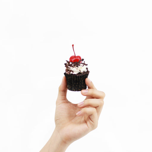Black forest cupcakes, topped with fresh cream, chocolate shavings and a red cherry