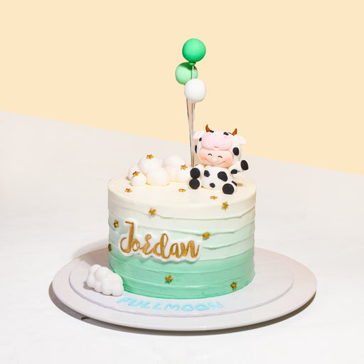 Green and white gradient buttercream cake, with a baby cow figurine
