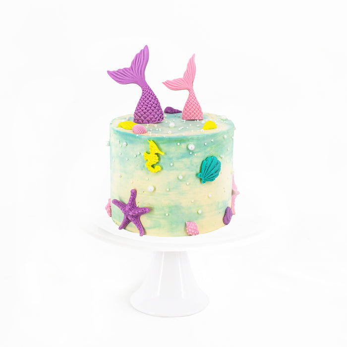 Green and white buttercream cake, with mermaid tail design elements