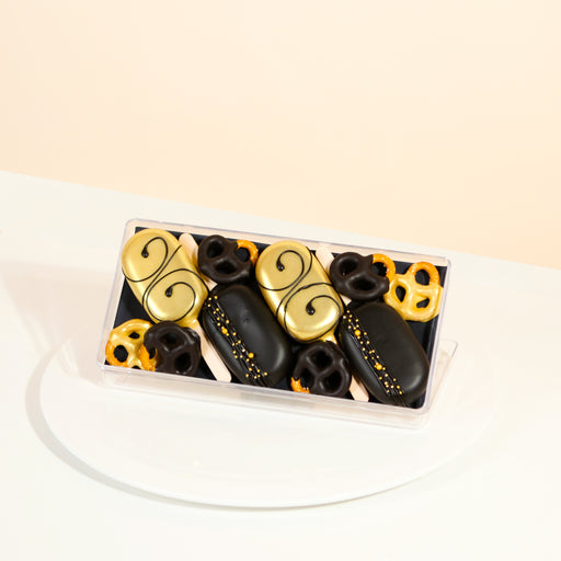 Gold and black chocolate covered cakesicles, with chocolate covered pretzels
