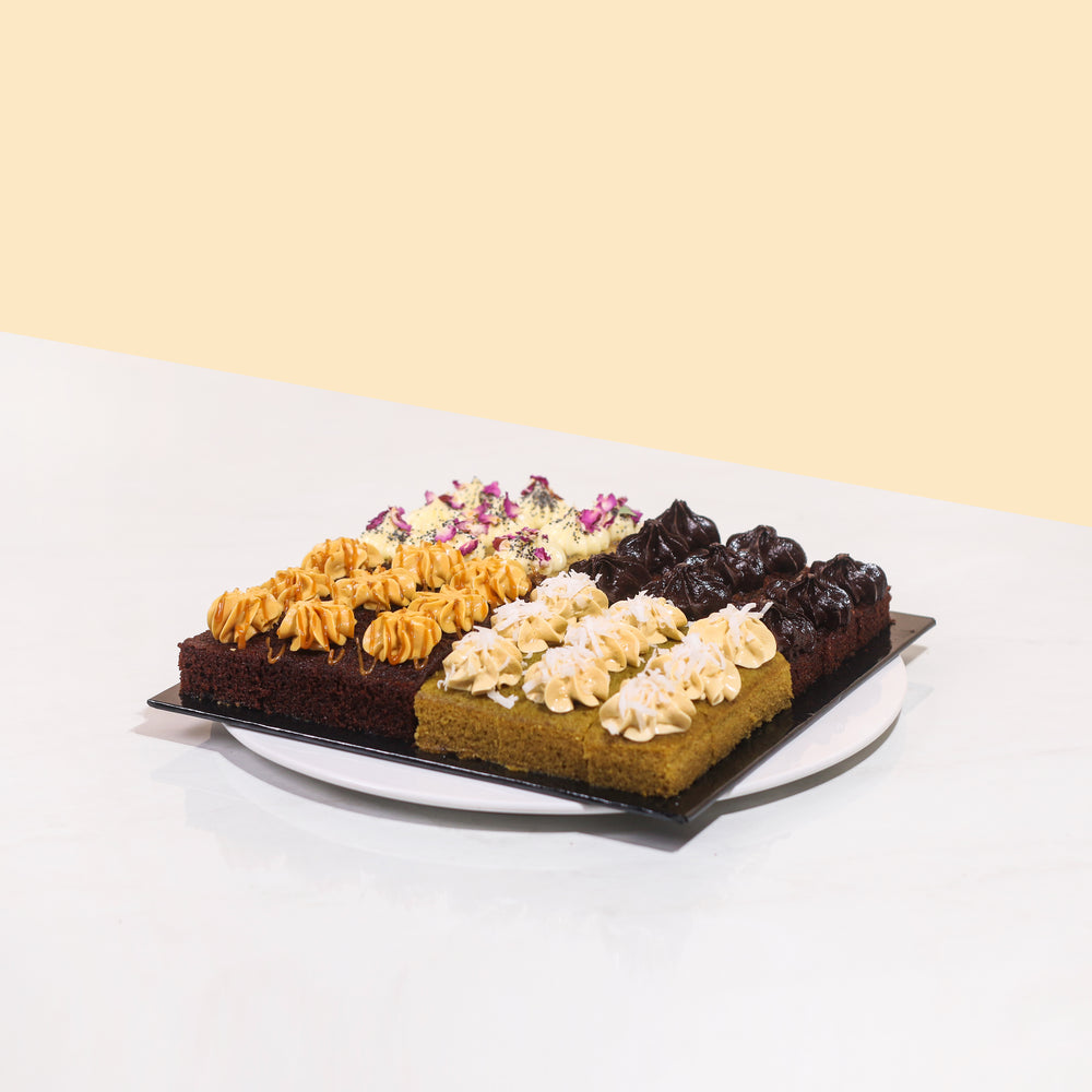 Platter of cake bites with four different flavours, them being Pandan, Chocolate, Salted Caramel and Lemon Poppyseed.