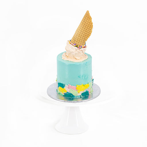 Buttercream cake with buttercream paint swipes, decorated with a ice cream cone