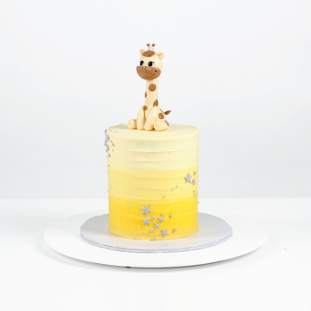 Cake decorated with ombre yellow buttercream, toppde with a fondant giraffe