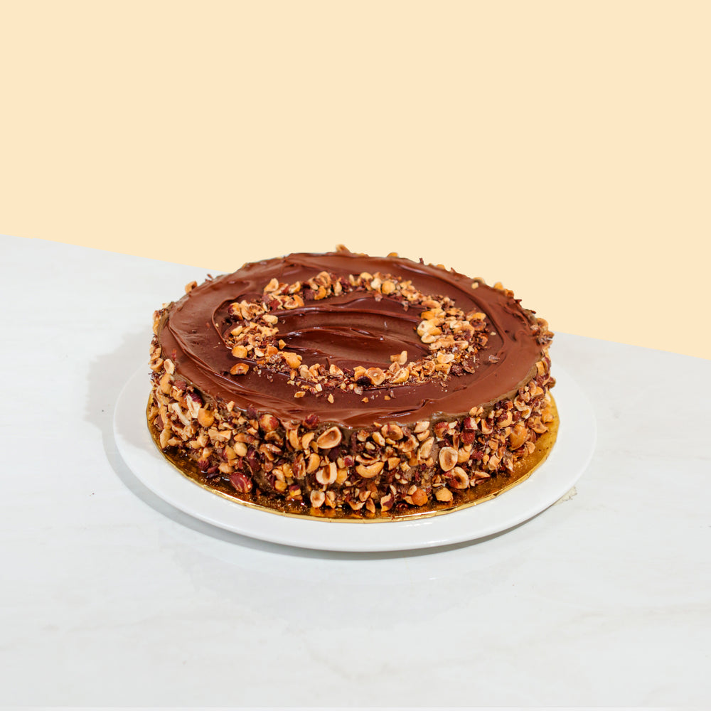 Cake coated with hazelnut spread, garnished with hazelnuts on the top and sides