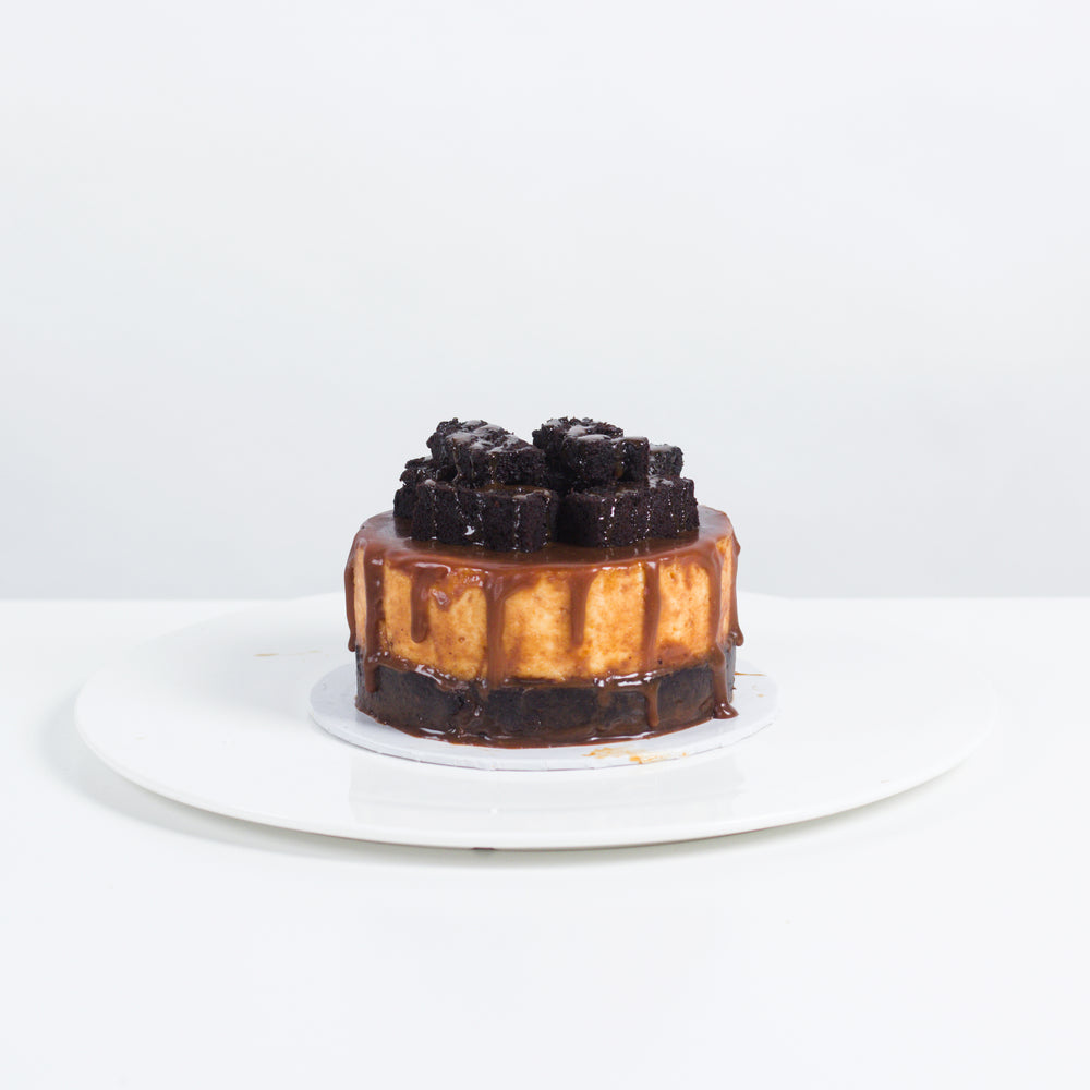 Cake with a base made of brownies, with a cheesecake on top, glazed in salted caramel