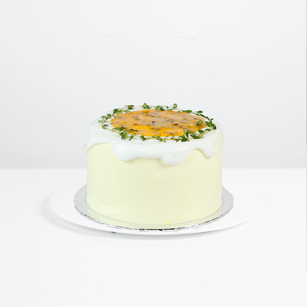 Orange chiffon cake, frosted with whipped cream, topped with passion fruit paste