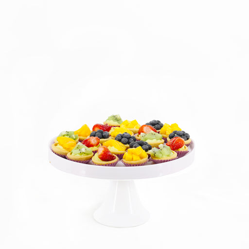 Tarts with smooth custard cream, topped with mangoes, peaches, strawberries and blueberries