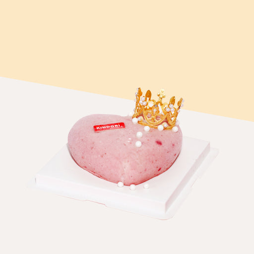 Heart shaped strawberry ice cream cake, with a golden crown topper