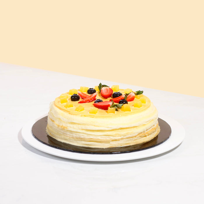 Crepe cake with mango cream and diced mangoes, topped with mango yogurt jelly and coconut jelly