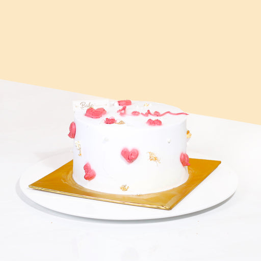 White Korean inspired cake with pink hearts and gold flakes