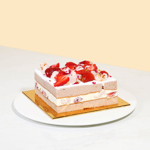 Cake layered with fruits and cream, garnished with strawberries and lychee