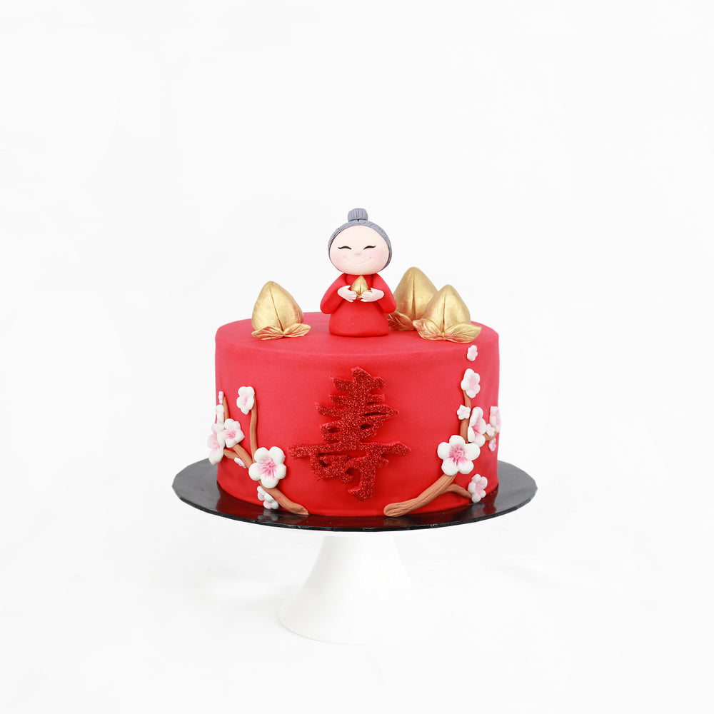 Red prosperity cake with an old lady figurine, golden peaches and sakura flowers