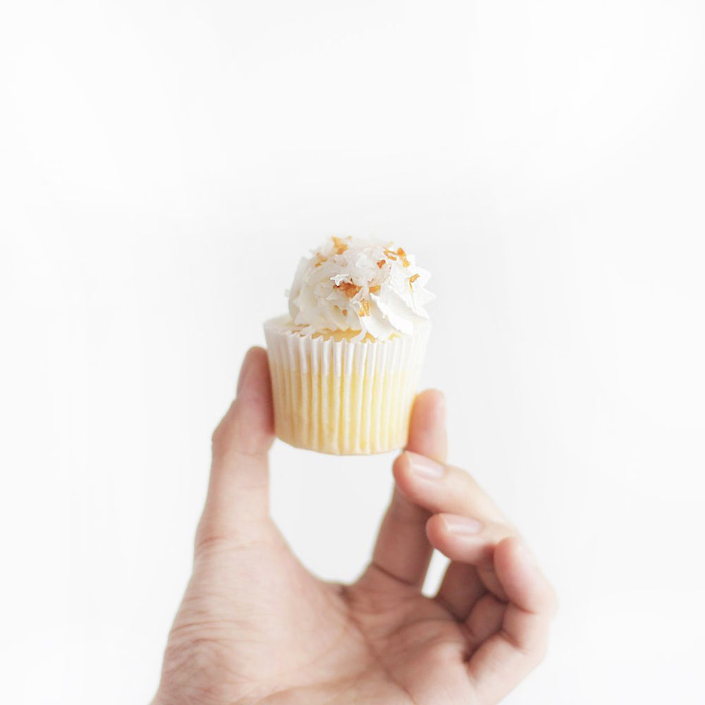 Cupcakes filled with lemon curd, buttercream, and toasted coconut flakes