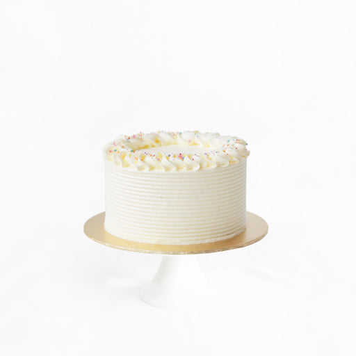 Classic butter cake with layers of buttercream, frosted in buttercream and topped with colorful sprinkles