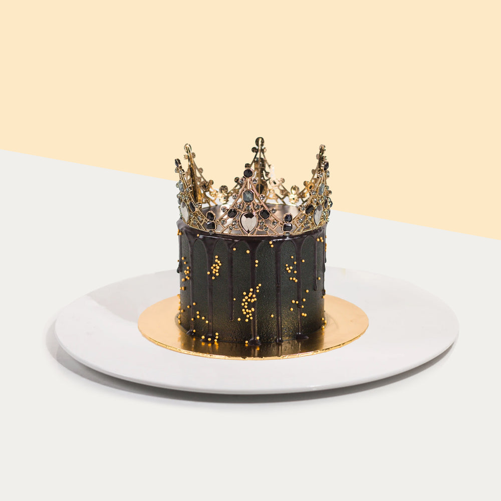 Cake with black buttercream frosting, topped with a crown