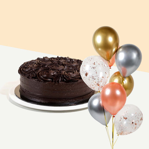 Chocolate cake coated head to toe with smooth chocolate cream, decorated with chocolate swirls with a bundle of balloons