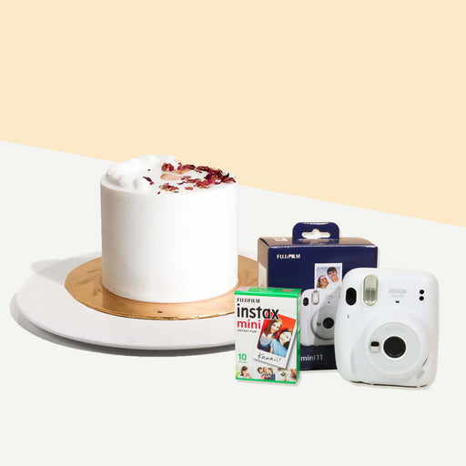 Cake covered in earl grey buttercream, garnished with dried rose petals with an Instax camera and film