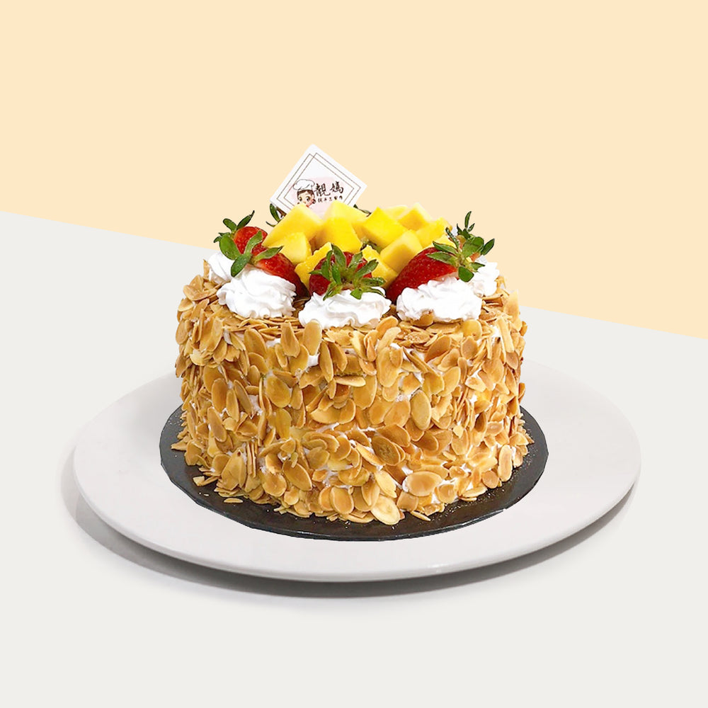 Chiffon cake layered with fresh cream and fruits, covered in toasted sliced almonds