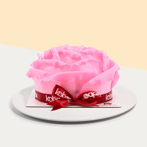 Cake decorated with pink chocolate fondant rose petals, wrapped with a ribbon