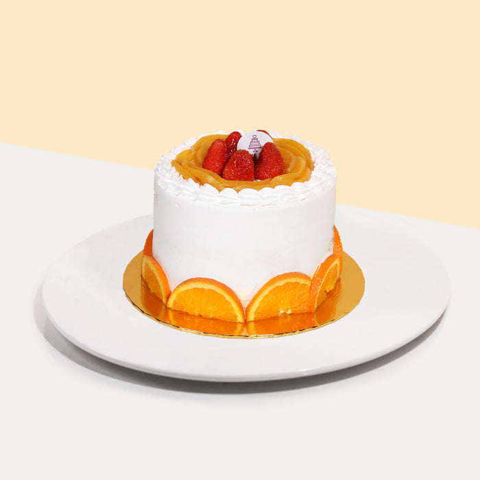 Vegan cake with orange slices, peaches and strawberries